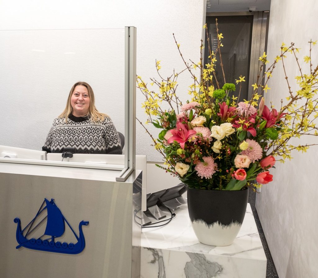 030922_Viking-NY_Candid-Office_2325_Lo-Res_cropped A woman sits behind the Viking reception desk.