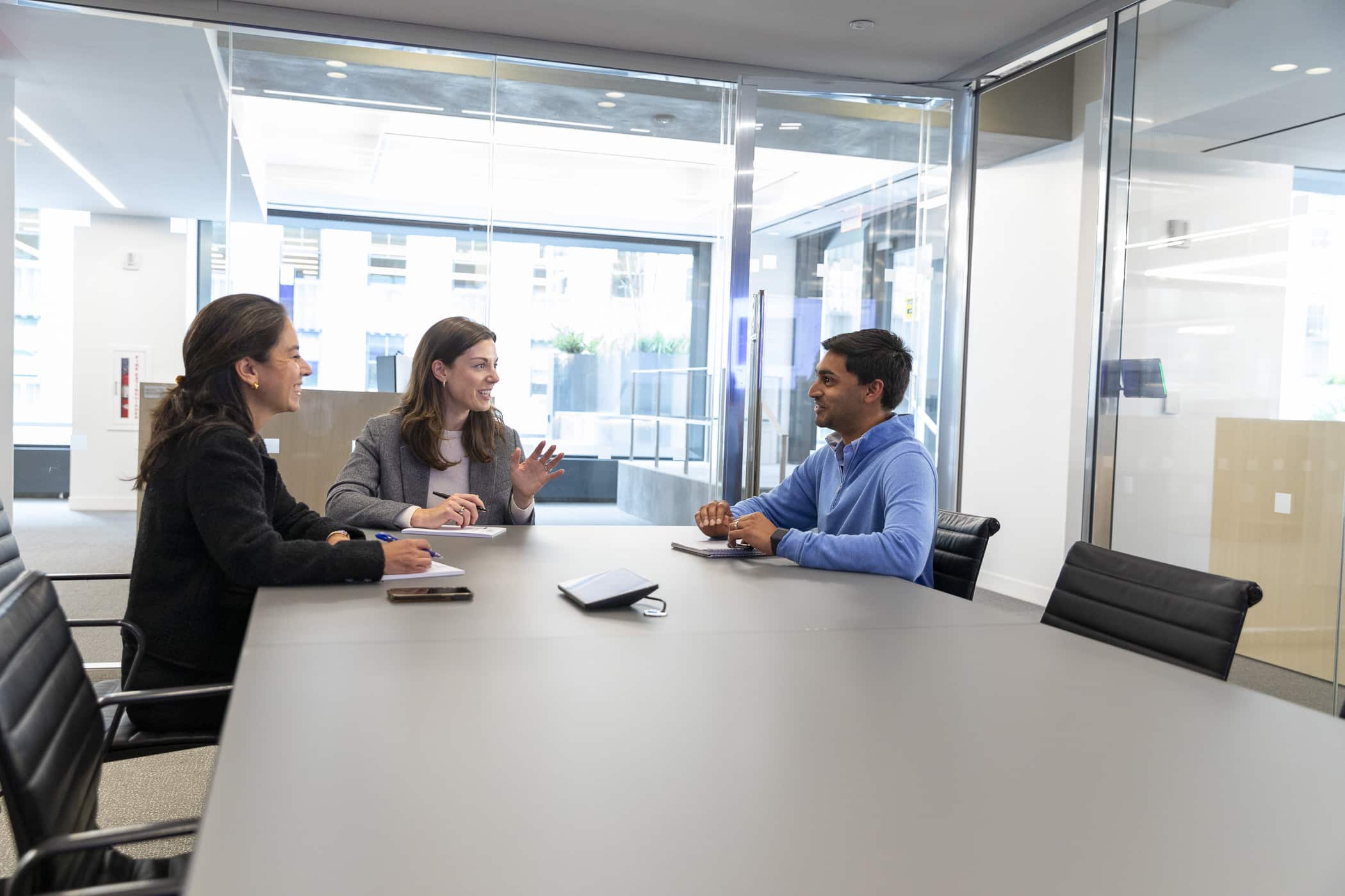 Three Viking team members in a glass-walled conference room engaged in a discussion.