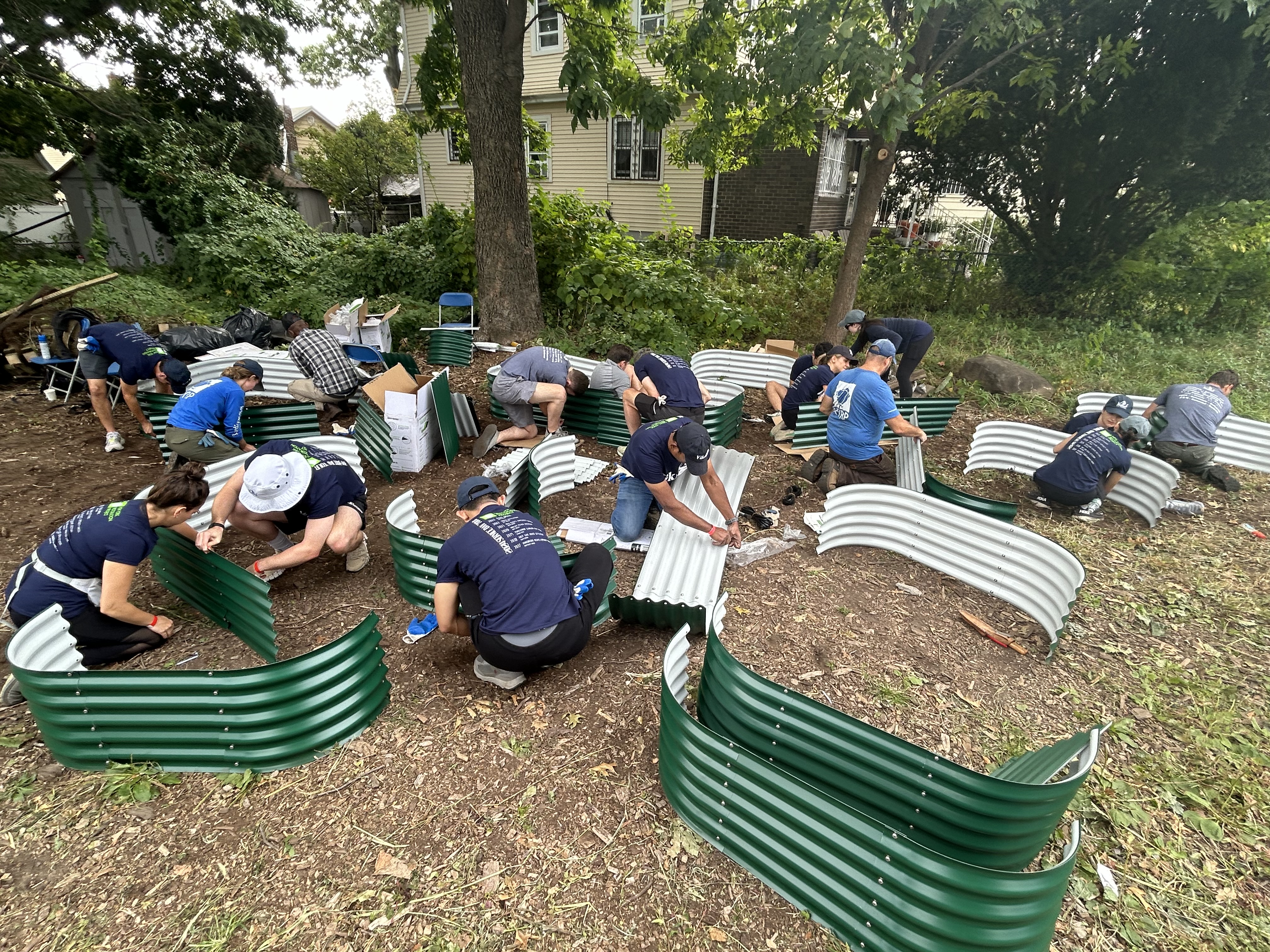 A yard filled with weeds in front of a brown building shows what the lot looked like before Vikings got involved as part of Service Day.